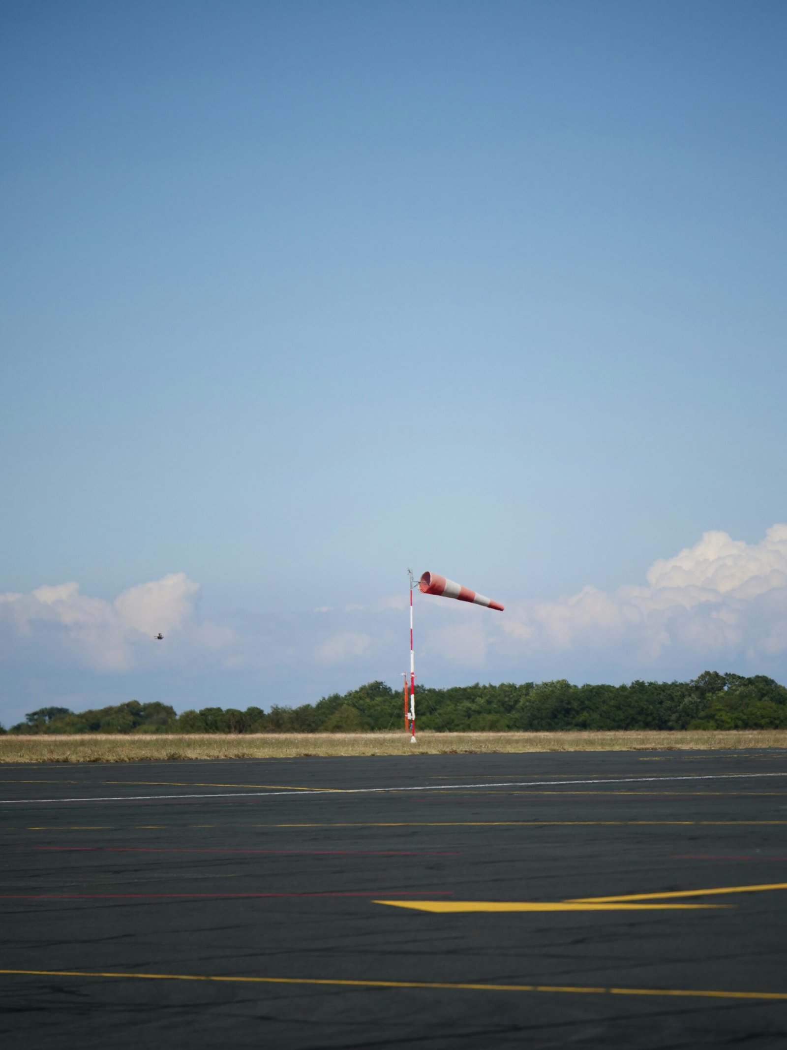 a red and white flag on a pole in an airport